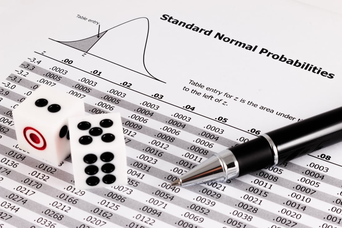 Two dice and pen on standard normal probabilities table.